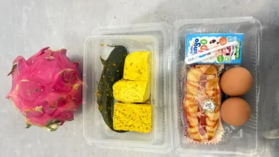 Petugas menyiapkan paket makanan Program Makan Bergizi Gratis sebelum didistribusikan kepada penerima manfaat.